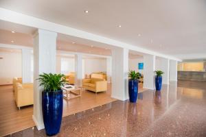 a lobby with three blue vases with plants in it at Hotel Santa Maria Playa in Cala Millor