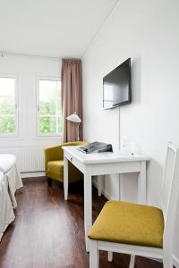 AlftaにあるGästisbackenのデスク、椅子、テーブルが備わる客室です。