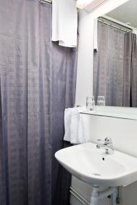 een badkamer met een wastafel en een douchegordijn bij Gästisbacken in Alfta