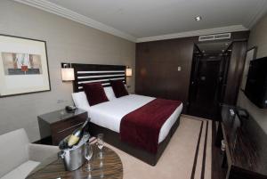 a bedroom with a bed and a table and a television at Hotel Los Peñascales - Adults Only in Las Rozas de Madrid