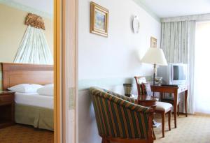 フィルツモースにあるHotel Alpenkroneのベッドとデスクが備わるホテルルームです。