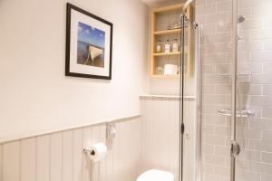 
a bathroom with a shower, toilet, and sink at The White Horse Blakeney in Blakeney
