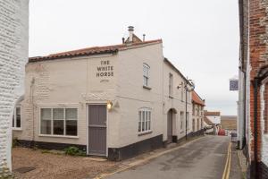 
a building with a sign on the side of it at The White Horse Blakeney in Blakeney
