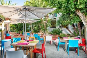 een restaurant met tafels en stoelen en een parasol bij Hotel La Santa Maria in Cala Millor