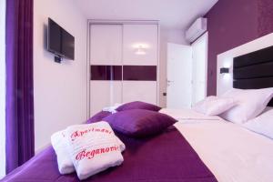 sypialnia z 2 łóżkami z fioletowymi i białymi poduszkami w obiekcie LUXURY VILLA BEGANOVIC-VRH w mieście Vrh