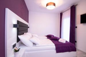 sypialnia z łóżkiem z fioletowymi i białymi poduszkami w obiekcie LUXURY VILLA BEGANOVIC-VRH w mieście Vrh