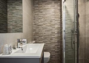 a bathroom with a sink and a toilet and a shower at Hostal Lar in Burgos
