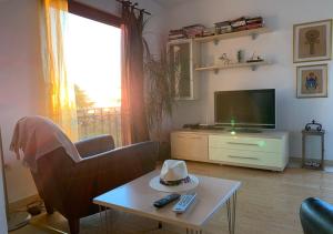 a living room with a television and a hat on a table at Regent Apartment in Petrovac na Moru