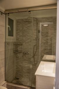 un bagno con doccia, lavandino e porta doccia in vetro di Your apartment in Athens (Next to Metro & Acropolis) ad Atene