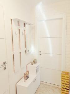 uma casa de banho branca com um lavatório e um espelho em Apartment Kesovija em Dubrovnik