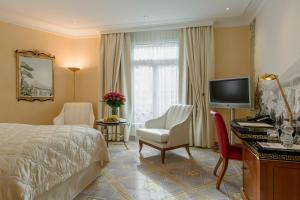 a hotel room with two beds and a television at Savoy Baur en Ville in Zurich