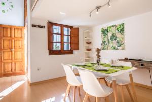 a white dining room with a white table and chairs at Abades Giralda Suite by Valcambre in Seville