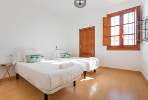 a room with two beds and a window at Abades Giralda Suite by Valcambre in Seville