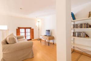 a living room with a couch and a table with a television at Abades Giralda Suite by Valcambre in Seville