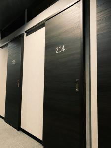a row of black doors with numbers on them at Hotel Capsule Inn Shizuoka in Shizuoka