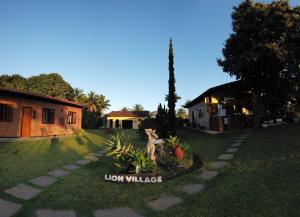 a yard with a sign that reads lion village at Sitio Toca do Leao in Guarapari