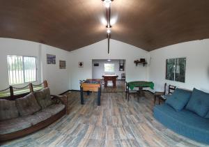 uma sala de estar com um sofá e uma mesa em Sitio Toca do Leao em Guarapari