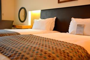 a hotel room with two beds and a mirror at Surmeli Istanbul Hotel in Istanbul