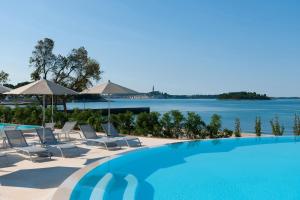 a swimming pool with chairs and a view of the water at Maistra Camping Amarin Mobile homes in Rovinj