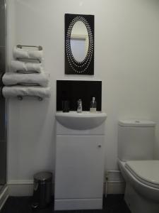 a bathroom with a sink and a toilet and a mirror at The Dundry Inn in Winford