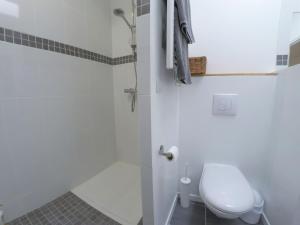 a white bathroom with a toilet and a shower at Le T2 moderne des Palmiers au coeur de Moissac in Moissac