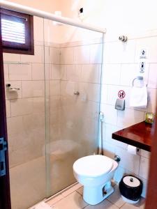 uma casa de banho com uma cabina de duche em vidro e um WC. em Hotel e Pousada La Dolce Vita em Canoa Quebrada