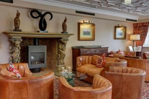 a living room with leather furniture and a fireplace at Best Western Premier Doncaster Mount Pleasant Hotel in Doncaster