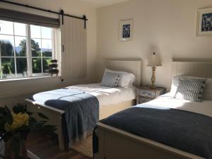 a bedroom with two beds and a window at The Happy Pig in Kenmare