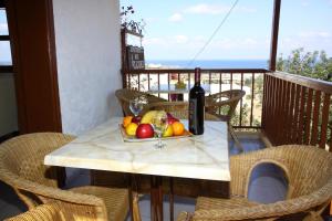 una mesa con un bol de fruta y una botella de vino en Elgoni Apartments, en Hersonissos