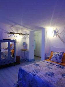 - une chambre avec un lit bleu et un miroir dans l'établissement La Terrazza on Acquaviva, à Marittima