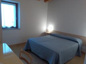a bedroom with a bed and a table and a window at Agriturismo Corte Maccini in Verona
