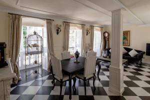 a dining room with a table and chairs on a checkered floor at Casa Valdes in Marbella