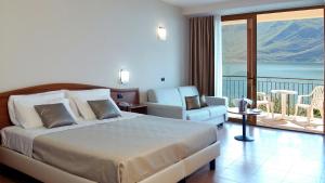 Habitación de hotel con cama y balcón en Hotel Mercedes en Limone sul Garda