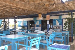 a restaurant with blue tables and white chairs at Aparthotel Ponta Preta in Santa Maria