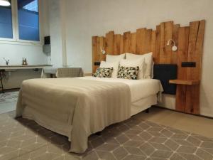 1 dormitorio con 1 cama grande y cabecero de madera en Oskorri, loft centrico y moderno, en Getaria