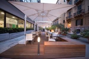 a restaurant with tables and chairs under an umbrella at Ibis Styles Palermo Cristal in Palermo