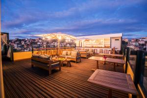 um terraço no último piso com bancos e mesas num edifício em Grand Hotel Urban em Antananarivo