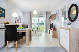 a kitchen and living room with a table and a dining room at Apartments Warsaw Obozowa by Renters in Warsaw