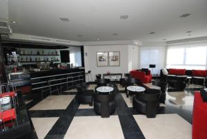 a lobby with a bar with black chairs and tables at Hotel Los Peñascales - Adults Only in Las Rozas de Madrid