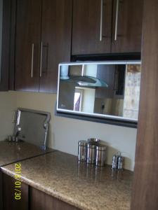 a kitchen with a counter top with a microwave at Kingdoms Place Guesthouse in Ga-Luka