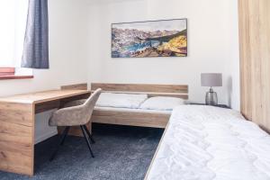 1 dormitorio con escritorio, 1 cama, escritorio y silla en TATRYSTAY Tatrahouse Luxury Apartment, en Stará Lesná