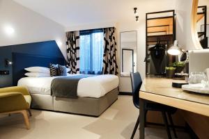 una camera d'albergo con letto e scrivania di The Fox & Goose Hotel a Londra