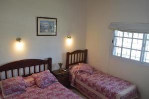 een slaapkamer met twee bedden en een raam bij Hostería San Benito in Concordia +33 foto's