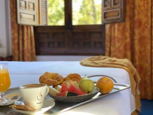 a tray of fruit on a table in a room at Hotel El Bedel in Alcalá de Henares