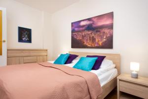 a bedroom with a bed with a large painting on the wall at Apartments Warsaw Arabska in Warsaw
