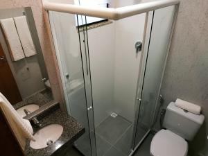 a bathroom with a shower and a toilet and a sink at Pousada Montanhas do Caparaó in Caparaó Velho
