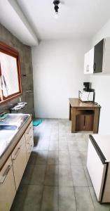 uma cozinha com armários brancos e piso em azulejo em Apto Jk em Cachoeirinha em Cachoeirinha