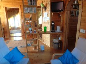 a living room of a log cabin with a tv at Family Home in Fáskrúðsfjörður