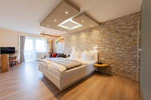 a bedroom with a large bed and a brick wall at Appartementhaus EifelAdventures in Berlingen +131 photos