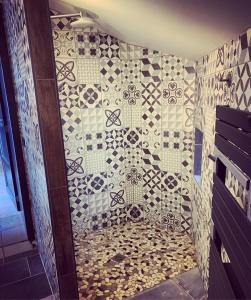 y baño con ducha y pared de azulejos. en Gite de La Belle Etable, en Falmignoul